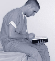 greenlight.jpg Man reading in a cell