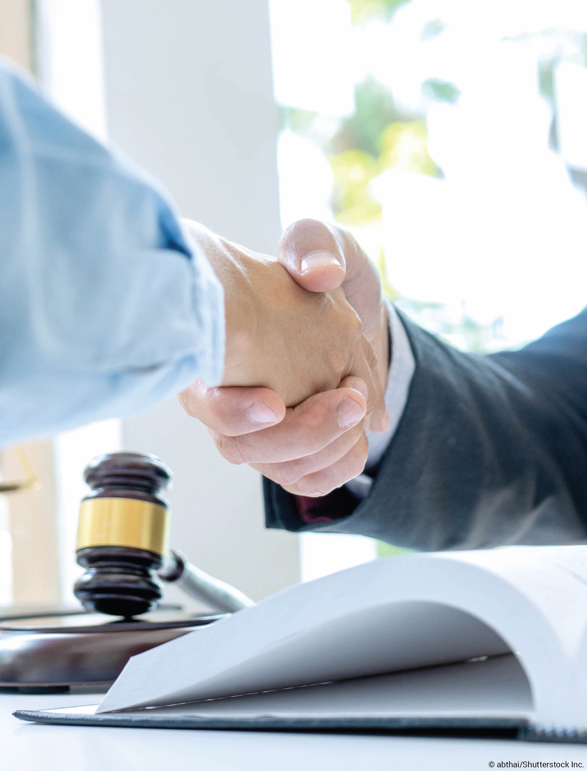 Hands shaking over gavel Hands shaking over gavel