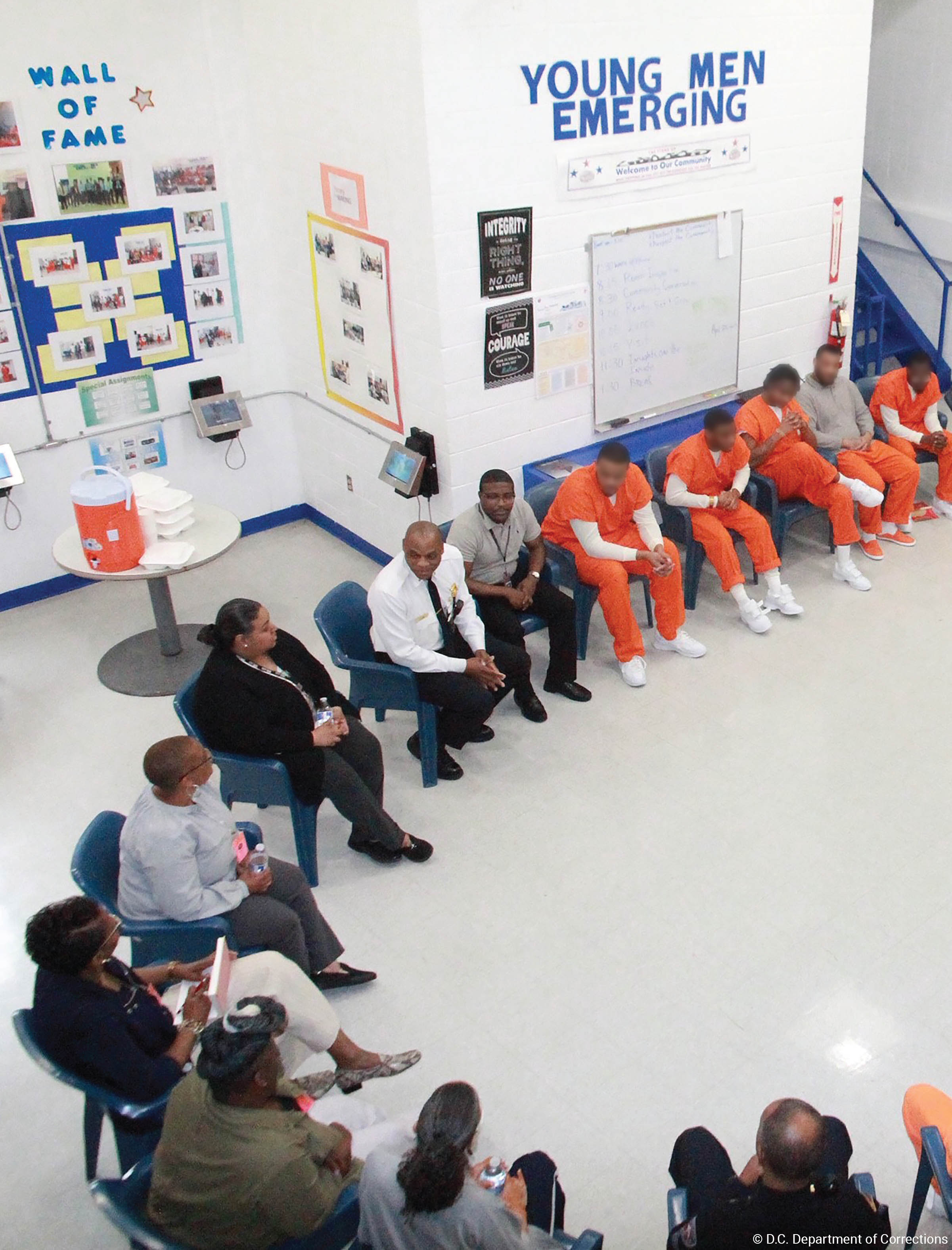 Inmates and program staff seated in a semi-circle Inmates and program staff seated in a semi-circle