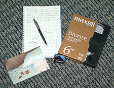 principles_of_dna_03_-_documentation.jpeg Photo of a notebook, a VHS tape, and a photo of a crime scene