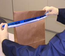 principles_of_dna_03_-_packaging.jpeg Photo of gloved hands holding up a brown paper evidence bag