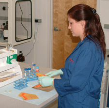 principles_of_dna_05_-_test_items.jpeg Lab Technician wearing gloves examining an envelope