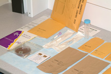 principles_of_dna_06_-_differential_extraction.jpeg Photo of a table with multiple evidence manila folders, as well as test tubes on it.