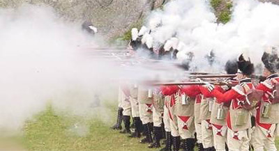 firearms_examiner_03_-_black_powder.jpg Photo of Revolutionary war red coated soldiers firing guns in a line