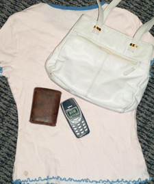 principles_of_dna_12_-_property.jpeg Photo of a woman's t shirt with a purse, wallet, and old 1990's cellphone on top