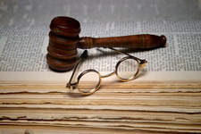 principles_of_dna_14_-_legal_issues.jpeg Photo of a judge's gavel, and old timey glasses on top of a law book