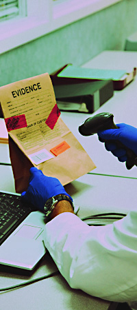 laboratory time and resources - scanning evidence.jpeg scientist scanning in a piece of evidence