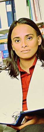 bph_cold_hits.jpeg Woman in a lab coat in front of stacks of books