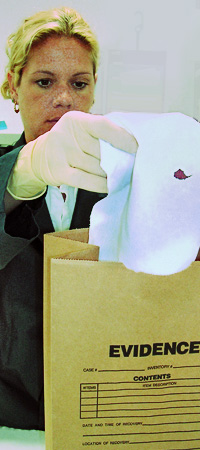 ltr_performlaboratoryanalysis.jpg Woman putting piece of evidence in a bag