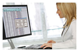 outsourcingconsiderations_4.jpeg Photo of a woman in a lab coat looking at a computer