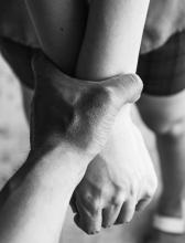 Hands being restrained A person's hands being restrained by another person's hand.